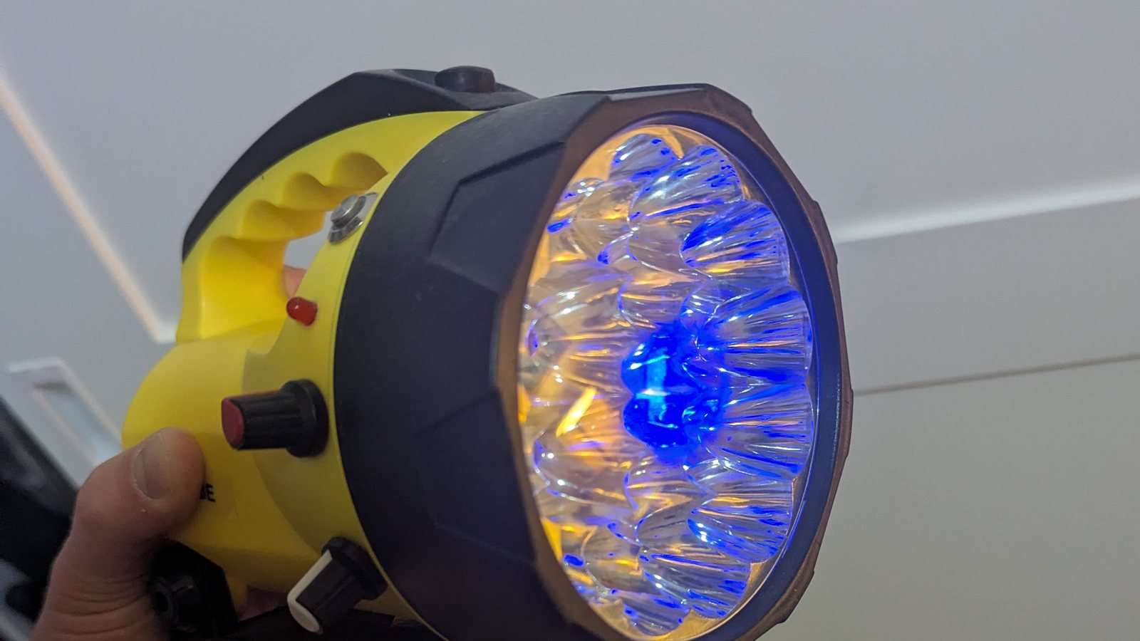 Front of the Arduino torch glowing blue in the middle of the original reflector