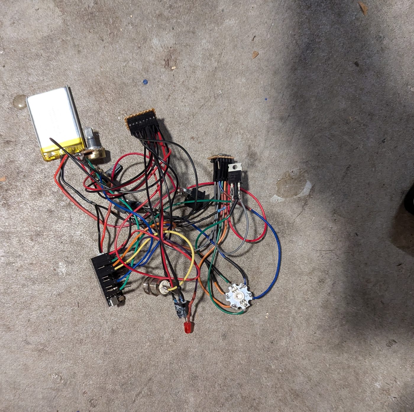 LiPo battery, MOSFETs, Qduino Mini and a tangle of wires laid out on a garage floor