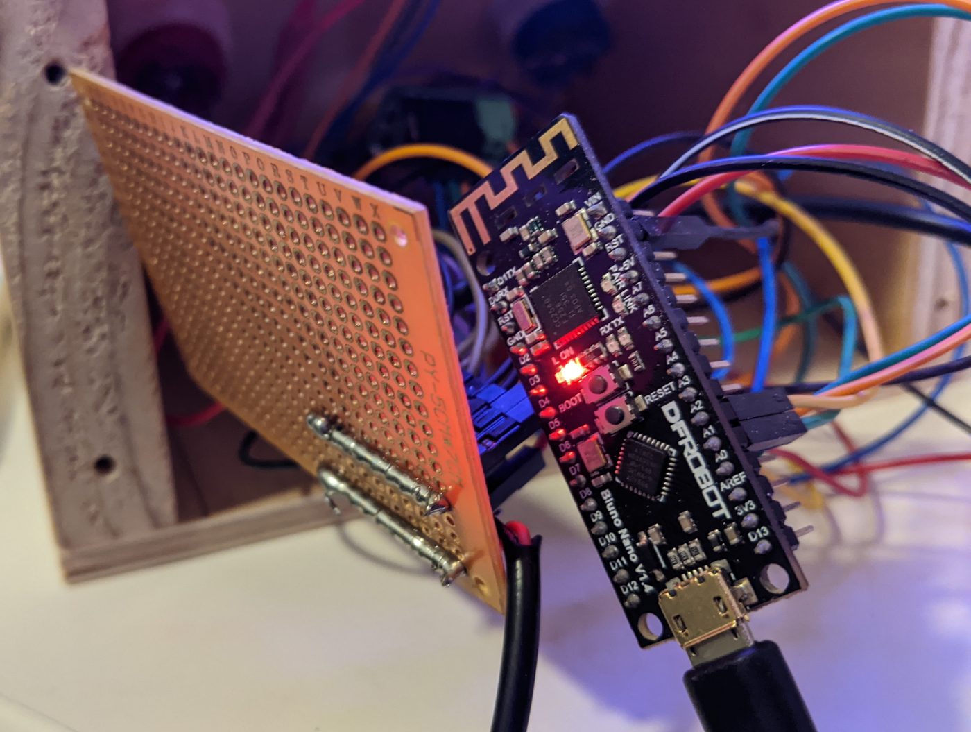 DFRobot Bluno Nano board on a prototype board next to the open plywood night light box