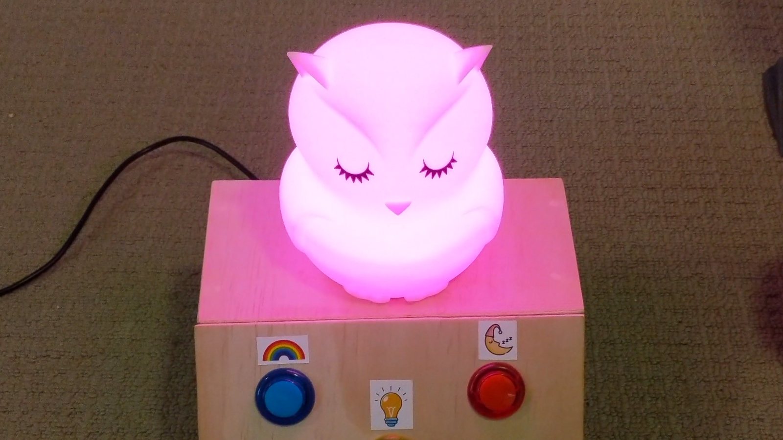 Arduino owl night light glowing pink on its plywood button box